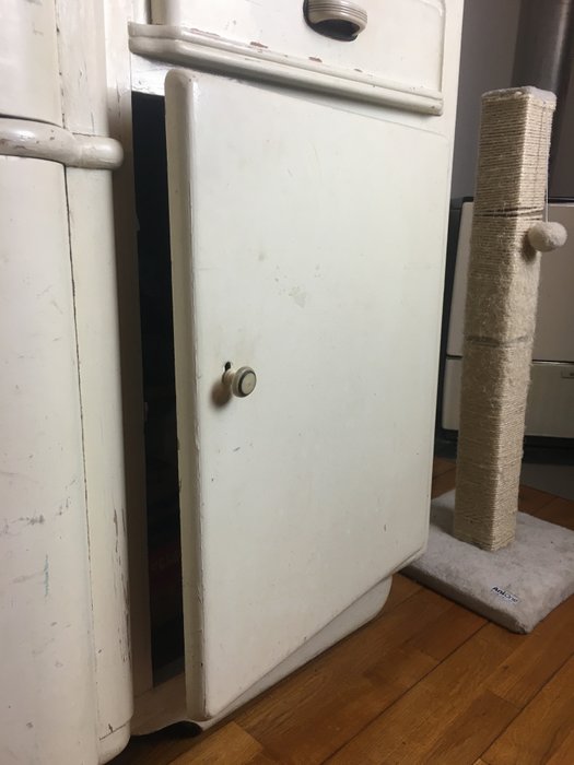 slightly opened cabinet door of an old buffet cabinet.