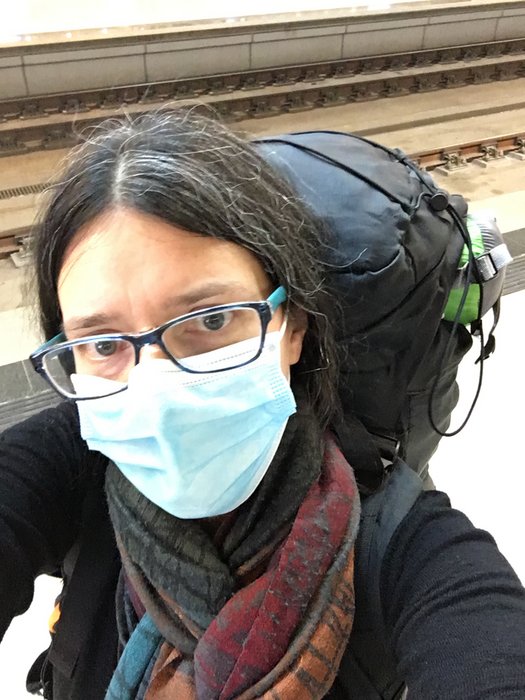 Portrait von Jennifer Scales mit großem Rucksack und medizinischer Maske